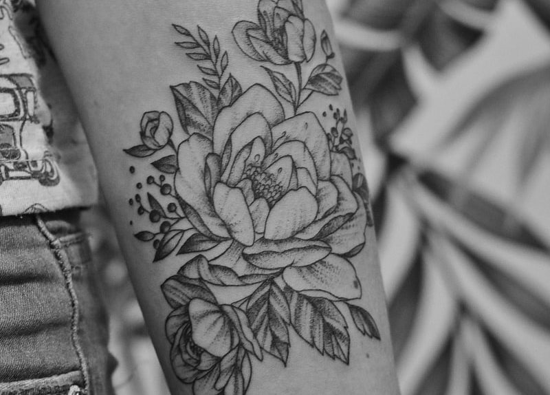 grayscale photo of floral arm tattoo